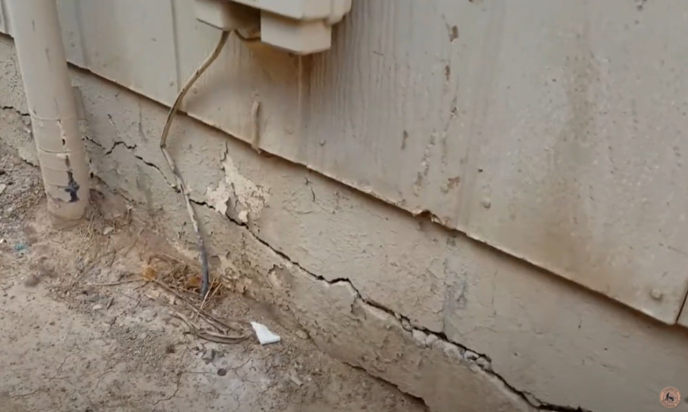 Homeowner reviewing DIY anchor bolt repair tools near a concrete foundation